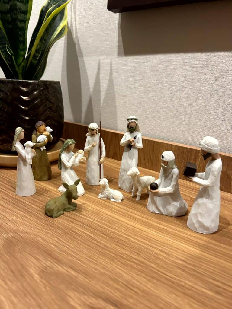 Santons de crèche en bois clair posés sur une table